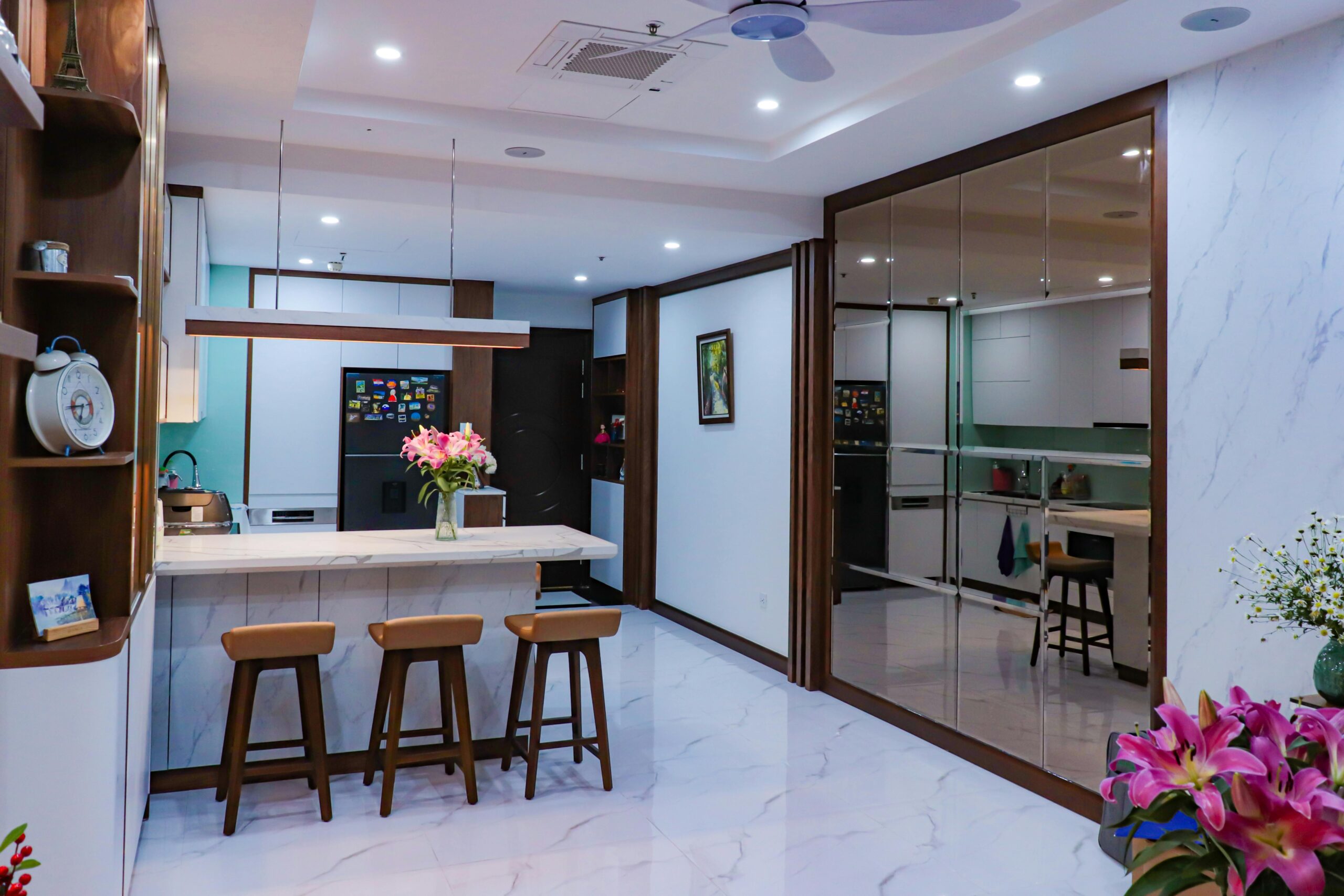Stylish interior of a modern kitchen with marble countertops and wooden decor elements.