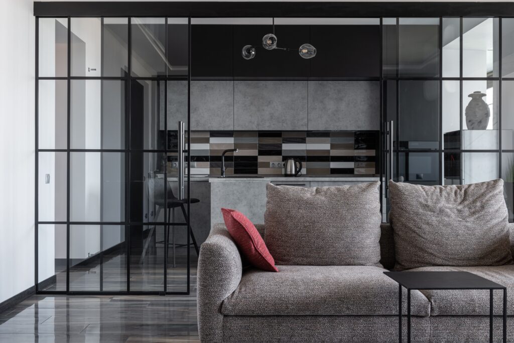 Contemporary living room with cozy sofa and open kitchen view.